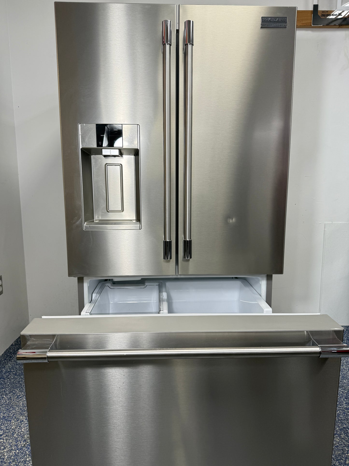 A view inside the bottom freezer drawer of the PRFS2883AF refrigerator, showing the wire basket and pull-out shelf for organized storage. On sale at Appliance Shark - Scratch & Dent store | Kansas City.