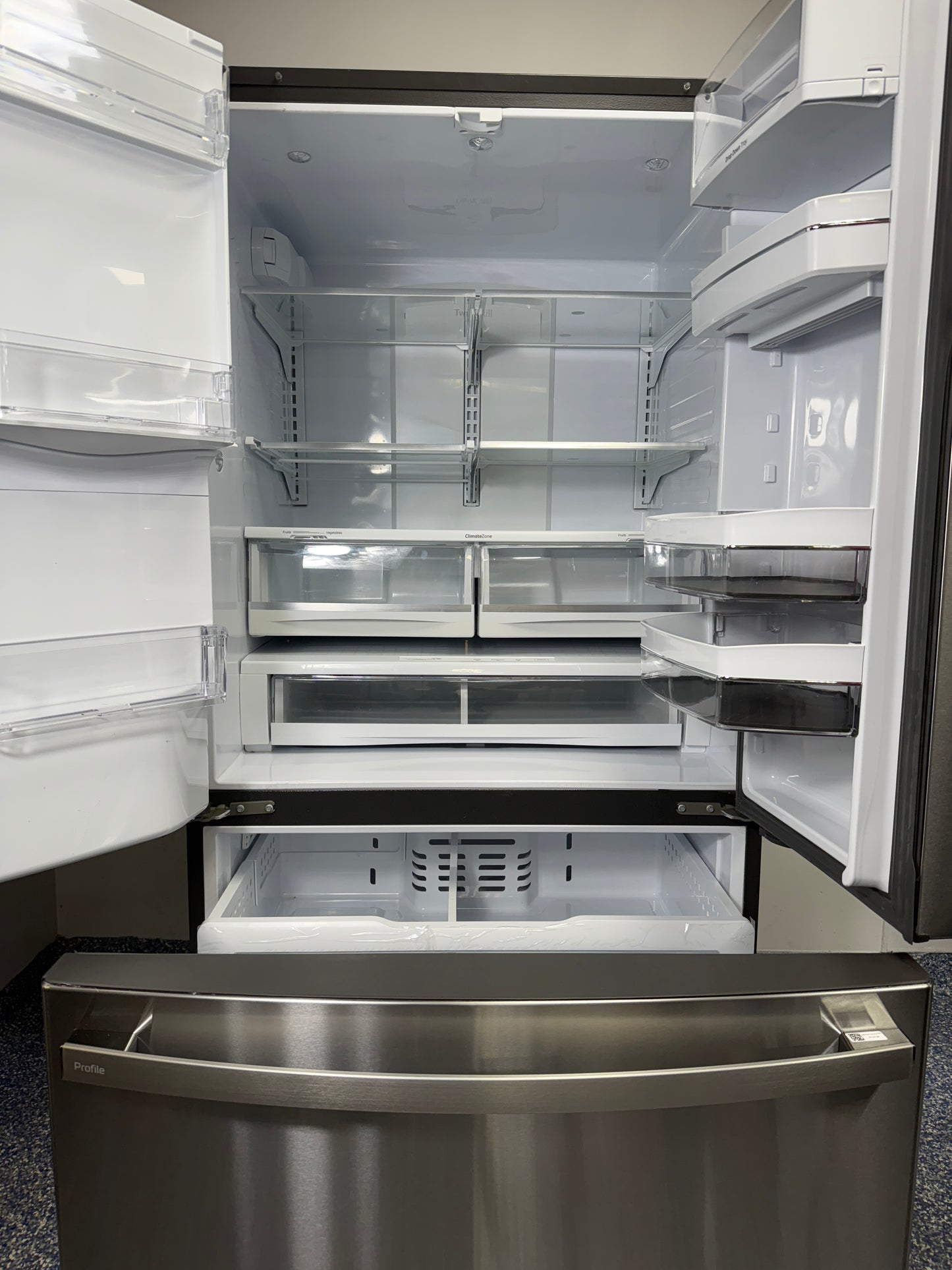 View of the GE Profile PFE28KYNFS refrigerator with all doors open, showing the spacious interior and adjustable shelving. On sale at Appliance Shark - Scratch & Dent store | Kansas City.