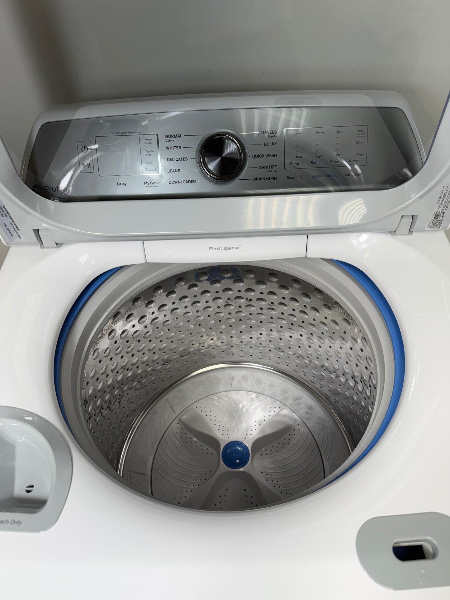 A close-up of the stainless steel wash drum interior of the PTW600BSRWS washer, featuring Microban® Antimicrobial Technology. On sale at Appliance Shark - Scratch & Dent store | Kansas City.