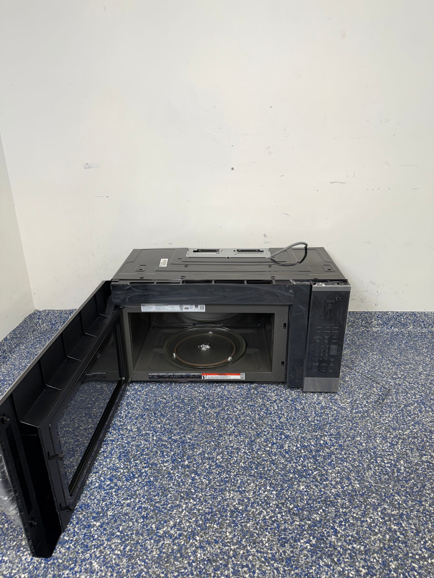 An overhead shot of the LG MVEM1825F with the door open, showcasing the spacious 1.8 cu ft interior. On sale at Appliance Shark - Scratch & Dent store | Kansas City.
