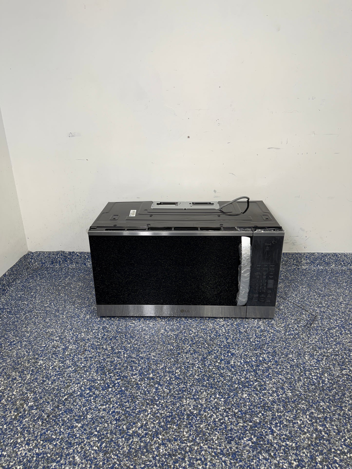 A full frontal image of the LG MVEM1825F over-the-range microwave, highlighting its Stainless Steel finish and sleek design. On sale at Appliance Shark - Scratch & Dent store | Kansas City.