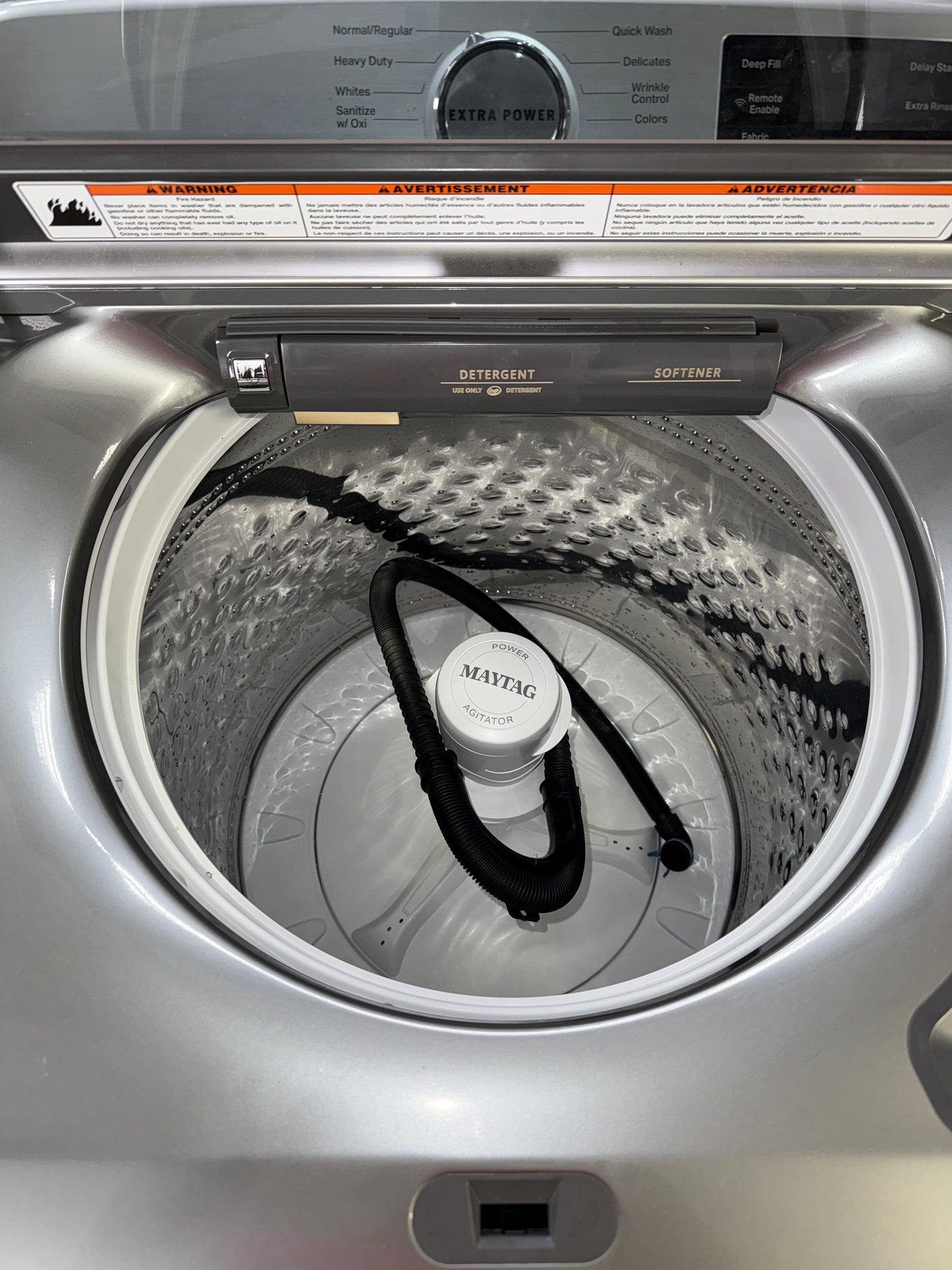 A front view of the MAYTAG MVW7230HC washer, highlighting its built-in water faucet, ready for installation in a Kansas City laundry room.