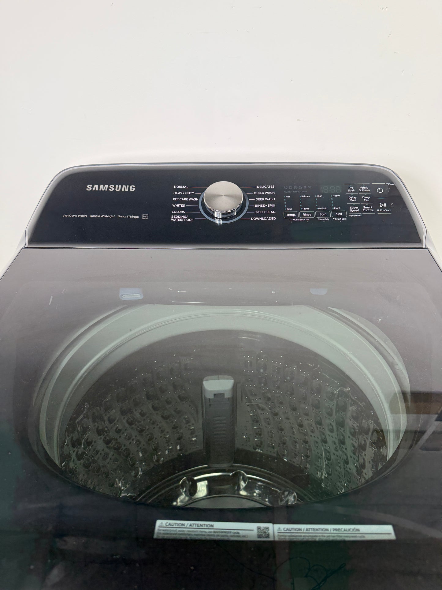 A detailed view of the digital control panel for the SAMSUNG WA54CG7150AD, showing the various wash cycles and LED display. On sale at Appliance Shark - Scratch & Dent store | Kansas City.