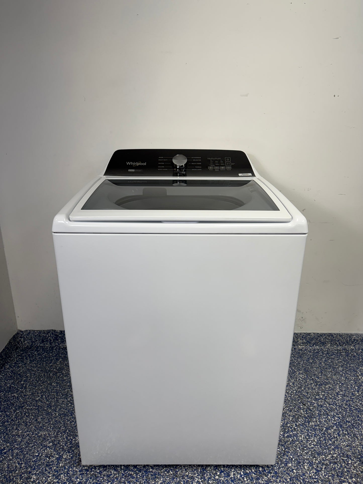 A full frontal photo of the WHIRLPOOL WTW5057LW top-load washing machine, showcasing its clean white finish and knob controls. Find this scratch & dent discount at our Kansas City store.