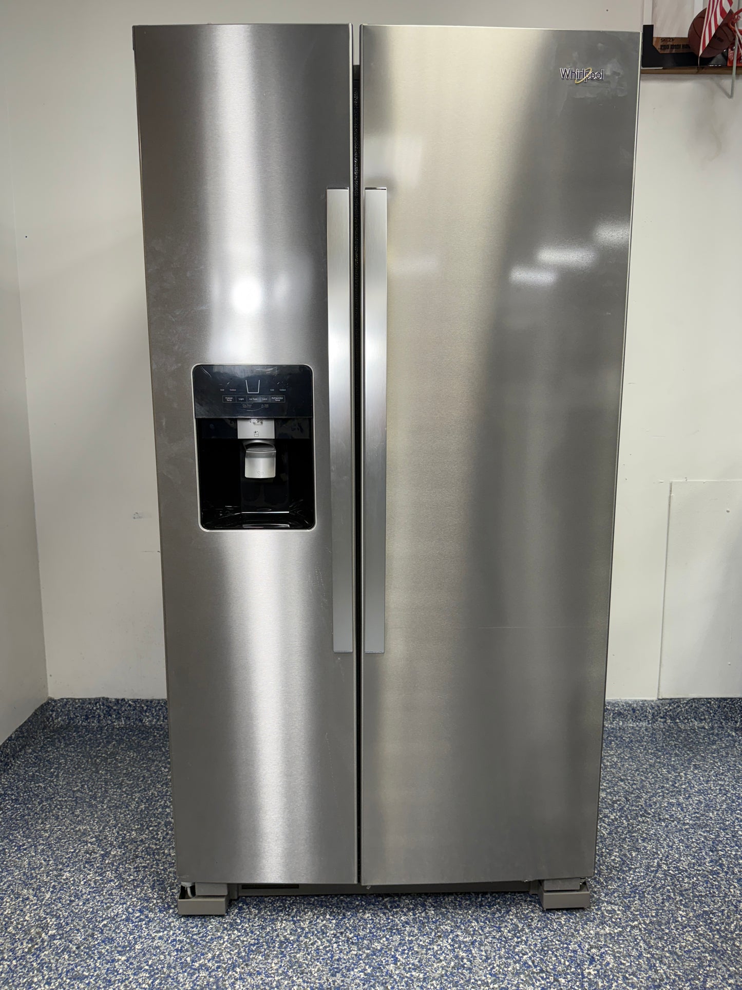A full view of the Whirlpool WRS325SDHZ side-by-side refrigerator in fingerprint-resistant stainless steel with an exterior water and ice dispenser.
