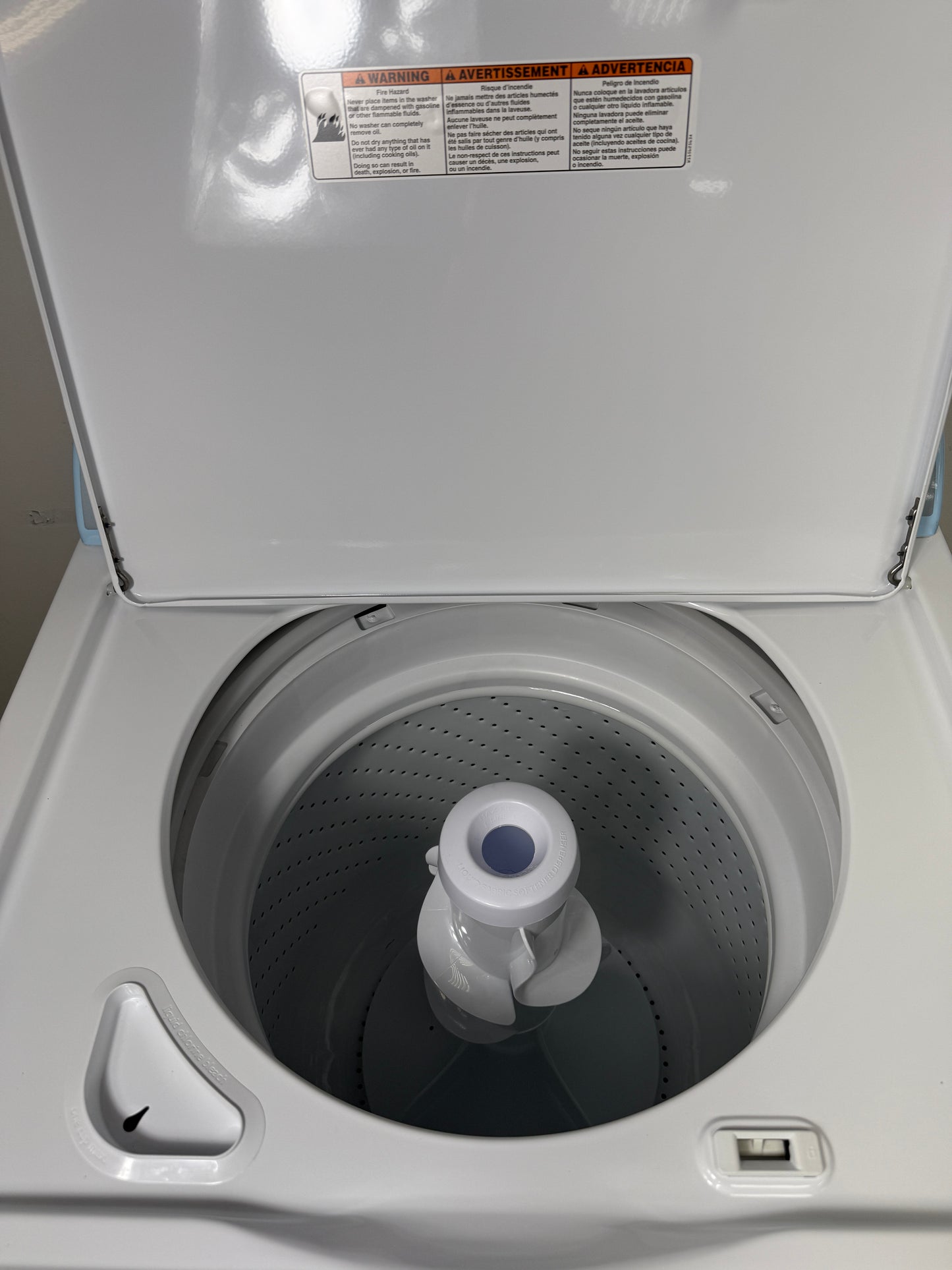 A close-up view of the interior of the Whirlpool WTW4816FW washer, highlighting the durable porcelain tub and dual-action agitator. On sale at Appliance Shark - Scratch & Dent store | Kansas City.