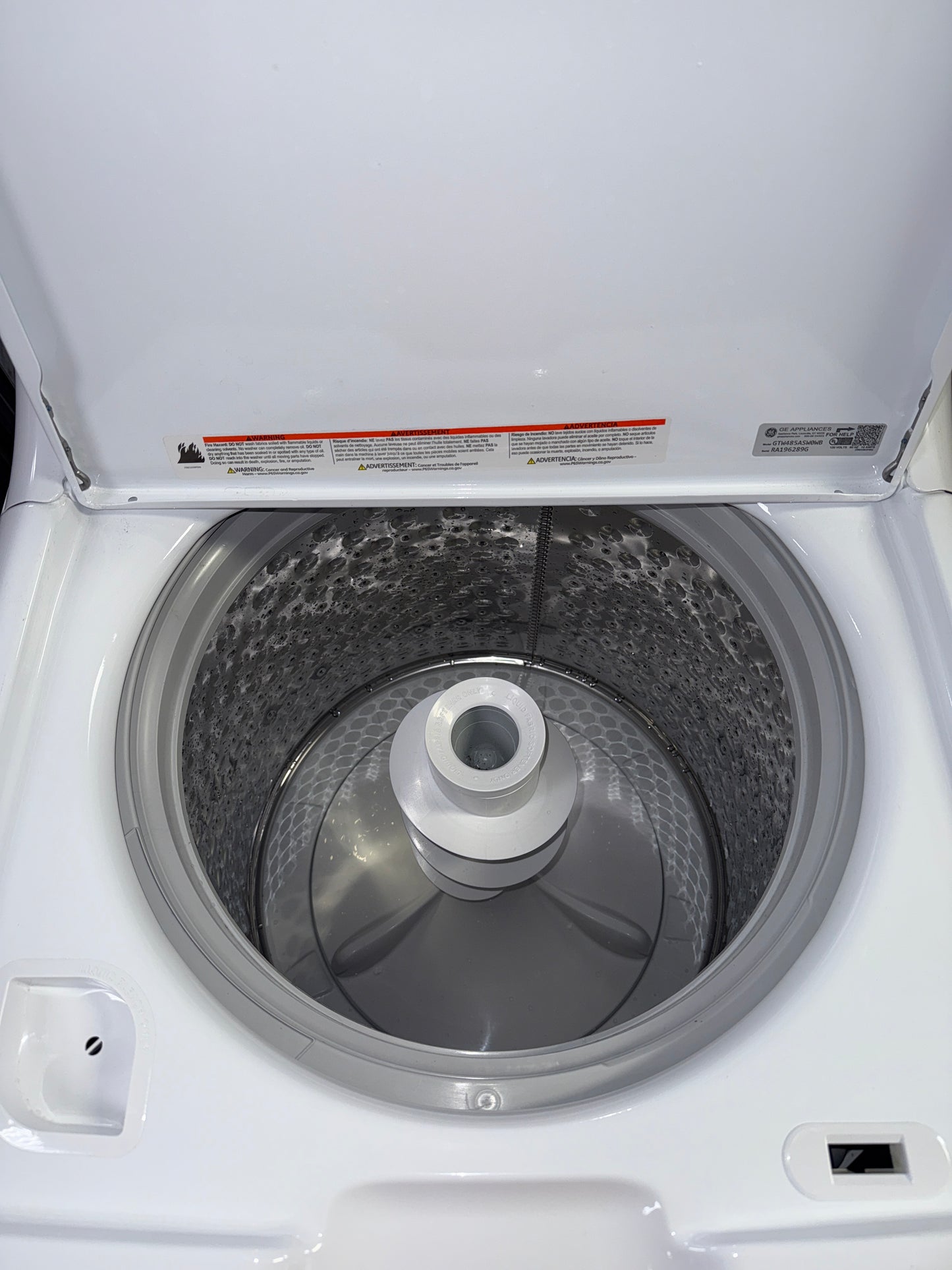 A front view of the GE GTW485ASW0WB washer, highlighting its Auto Sensing technology, ready for installation in a Kansas City laundry room.