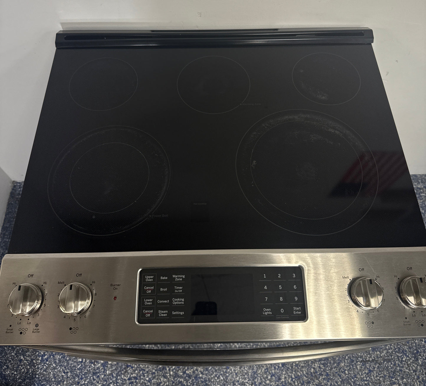 Smooth ceramic glass cooktop of the GE JSS86SP8SS range with Dual Power Boil elements, shown in Overland Park, KS.