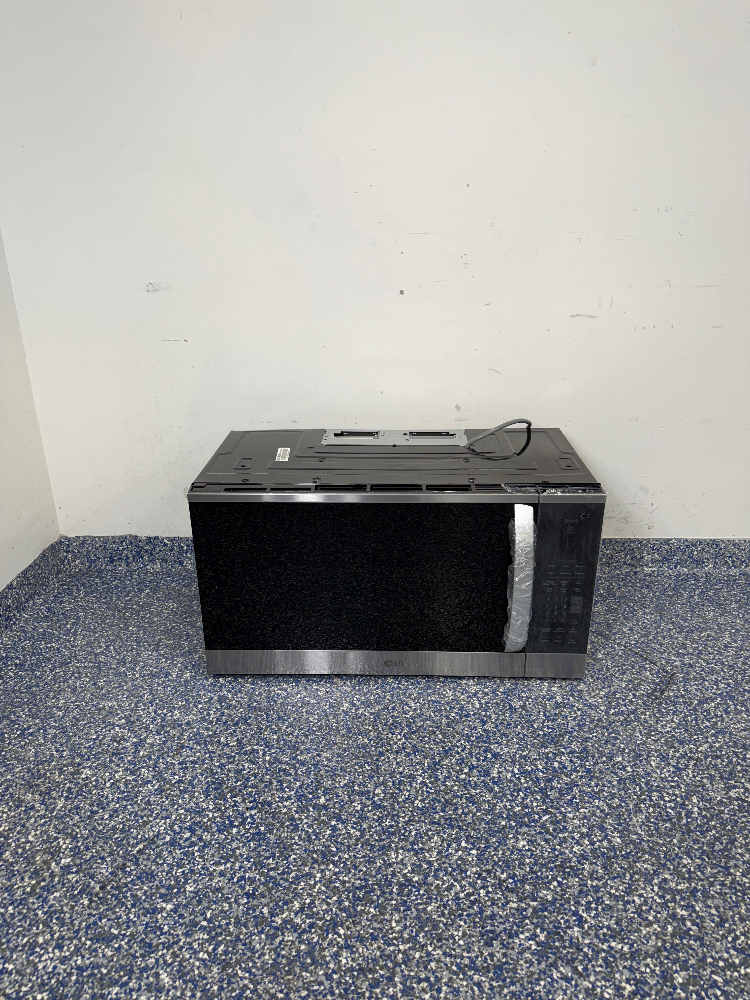 A full frontal image of the LG MVEM1825F over-the-range microwave, highlighting its Stainless Steel finish and sleek design. On sale at Appliance Shark - Scratch & Dent store | Kansas City.