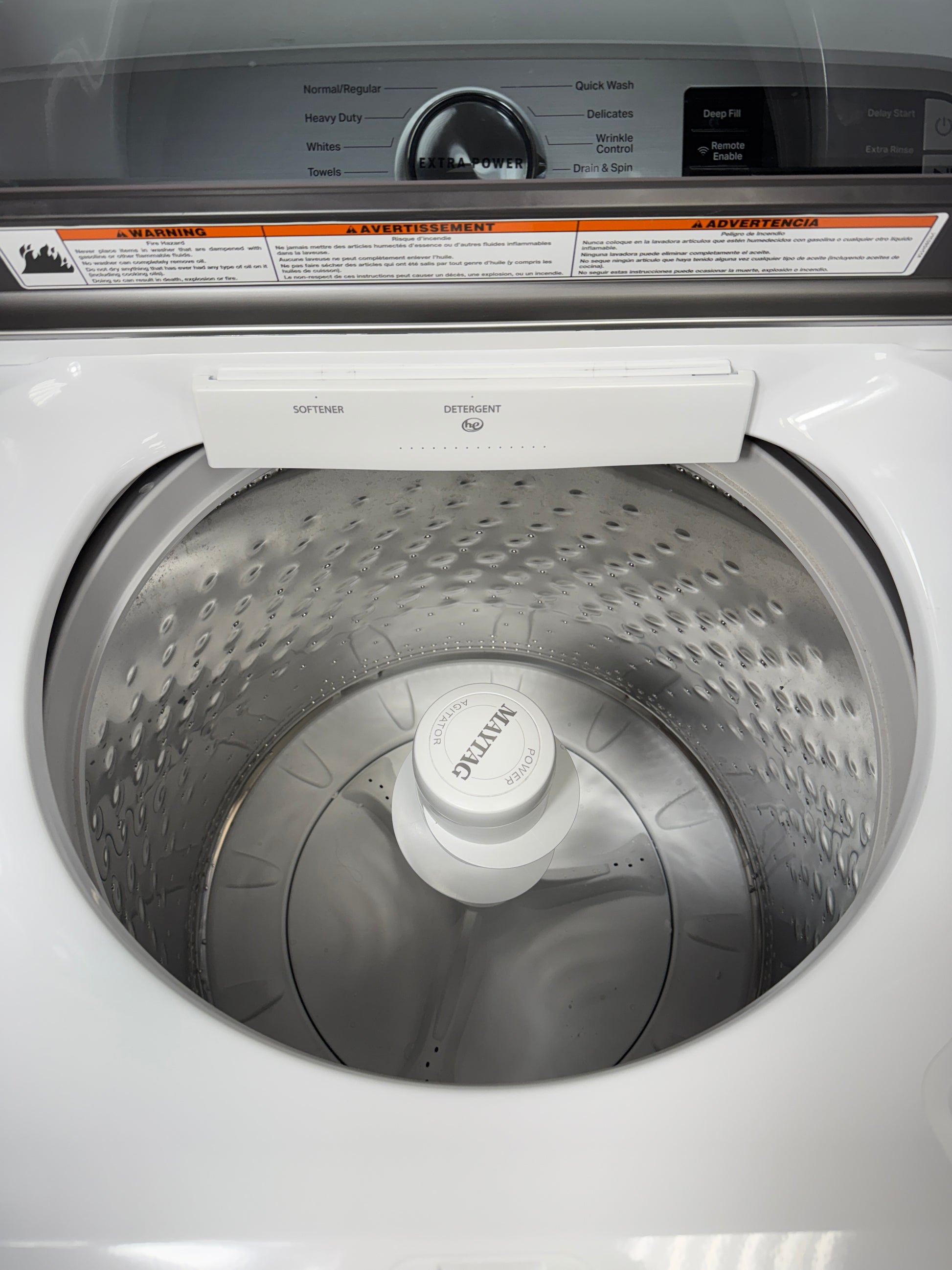 A close-up of the durable stainless steel wash basket and agitator inside the MVW6230HW washer, designed for tough messes. On sale at Appliance Shark - Scratch & Dent store | Kansas City.
