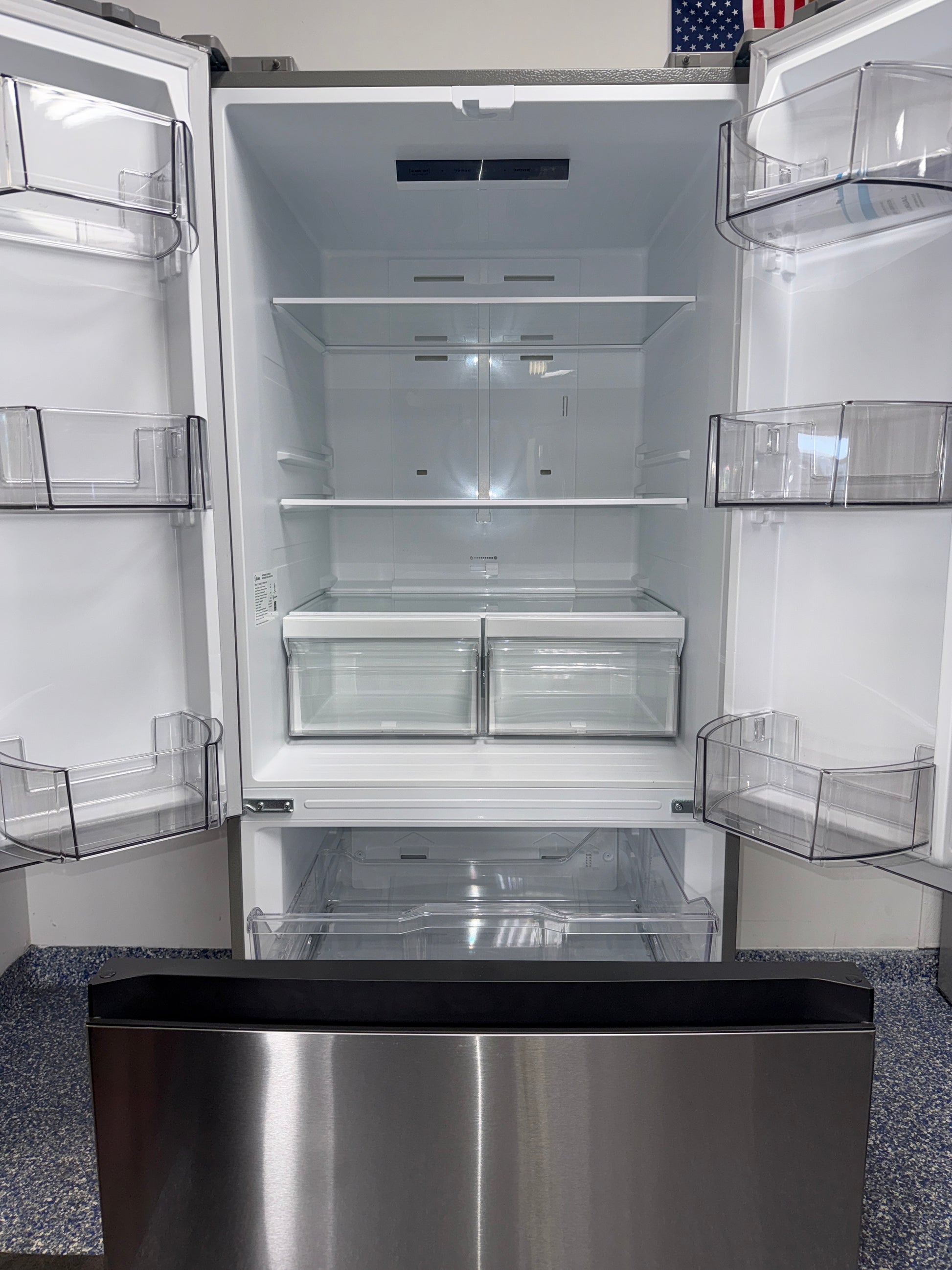Open-door view showing interior storage layout of the MIDEA MRF18B4AST refrigerator, featured in Kansas City homes.