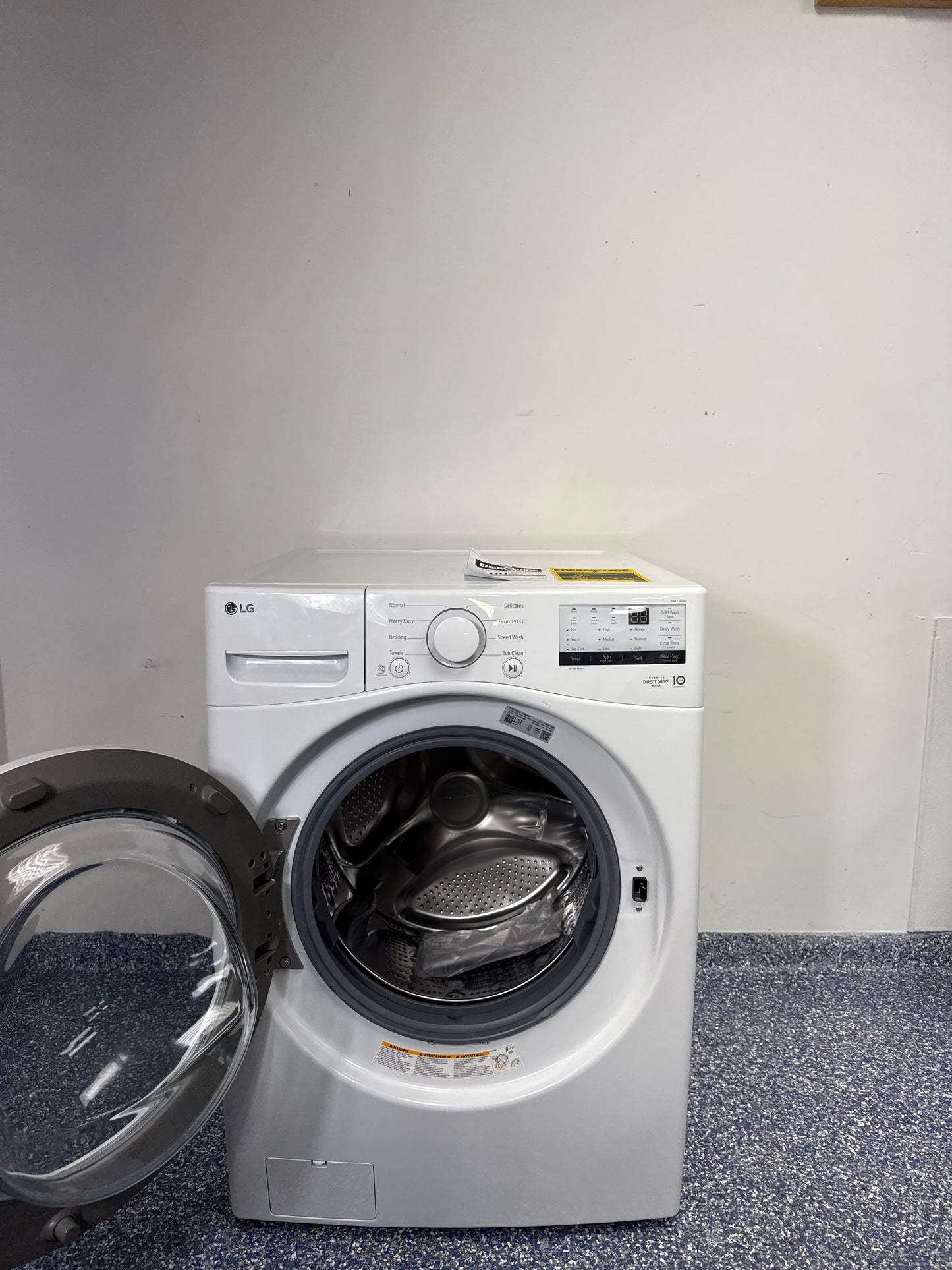 A close-up view of the wash cylinder of the LG WM3400CW washer, highlighting the NeveRust stainless steel and large capacity. This scratch and dent appliance is available at a discount in Kansas City.