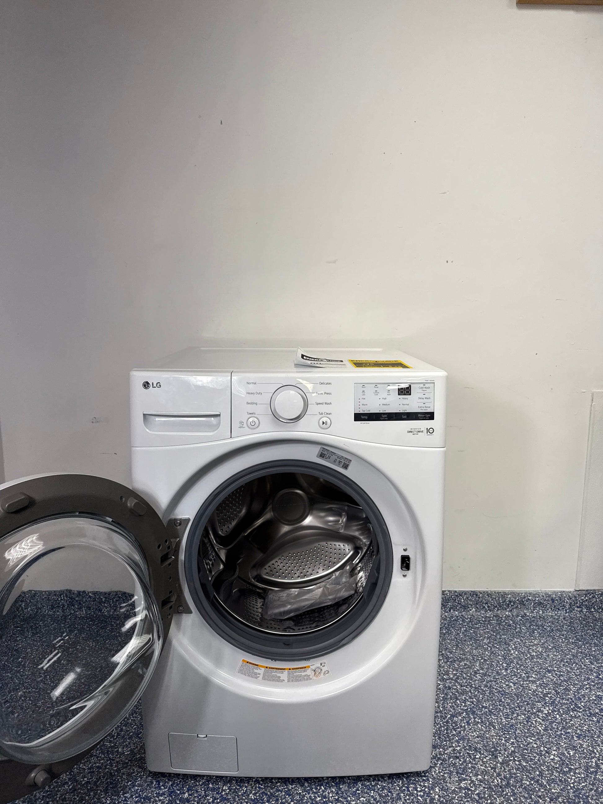 A close-up view of the wash cylinder of the LG WM3400CW washer, highlighting the NeveRust stainless steel and large capacity. This scratch and dent appliance is available at a discount in Kansas City.