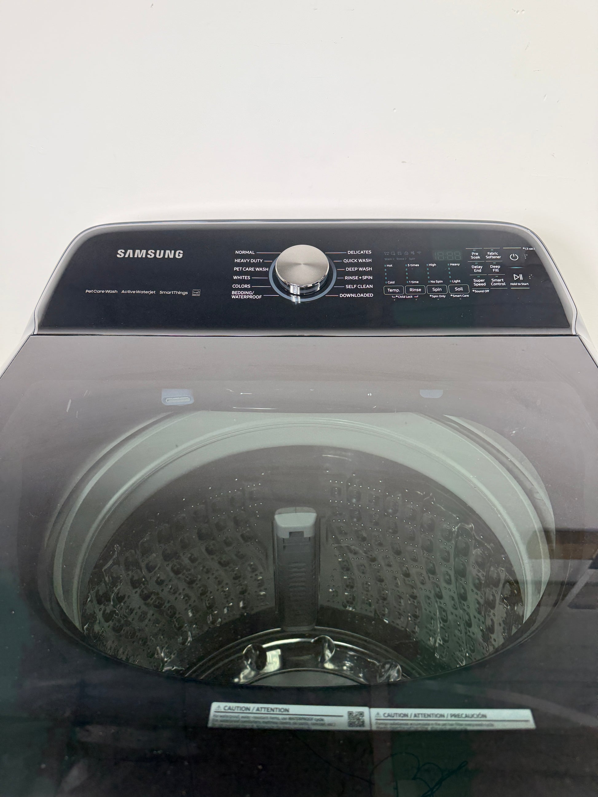 A detailed view of the digital control panel for the SAMSUNG WA54CG7150AD, showing the various wash cycles and LED display. On sale at Appliance Shark - Scratch & Dent store | Kansas City.