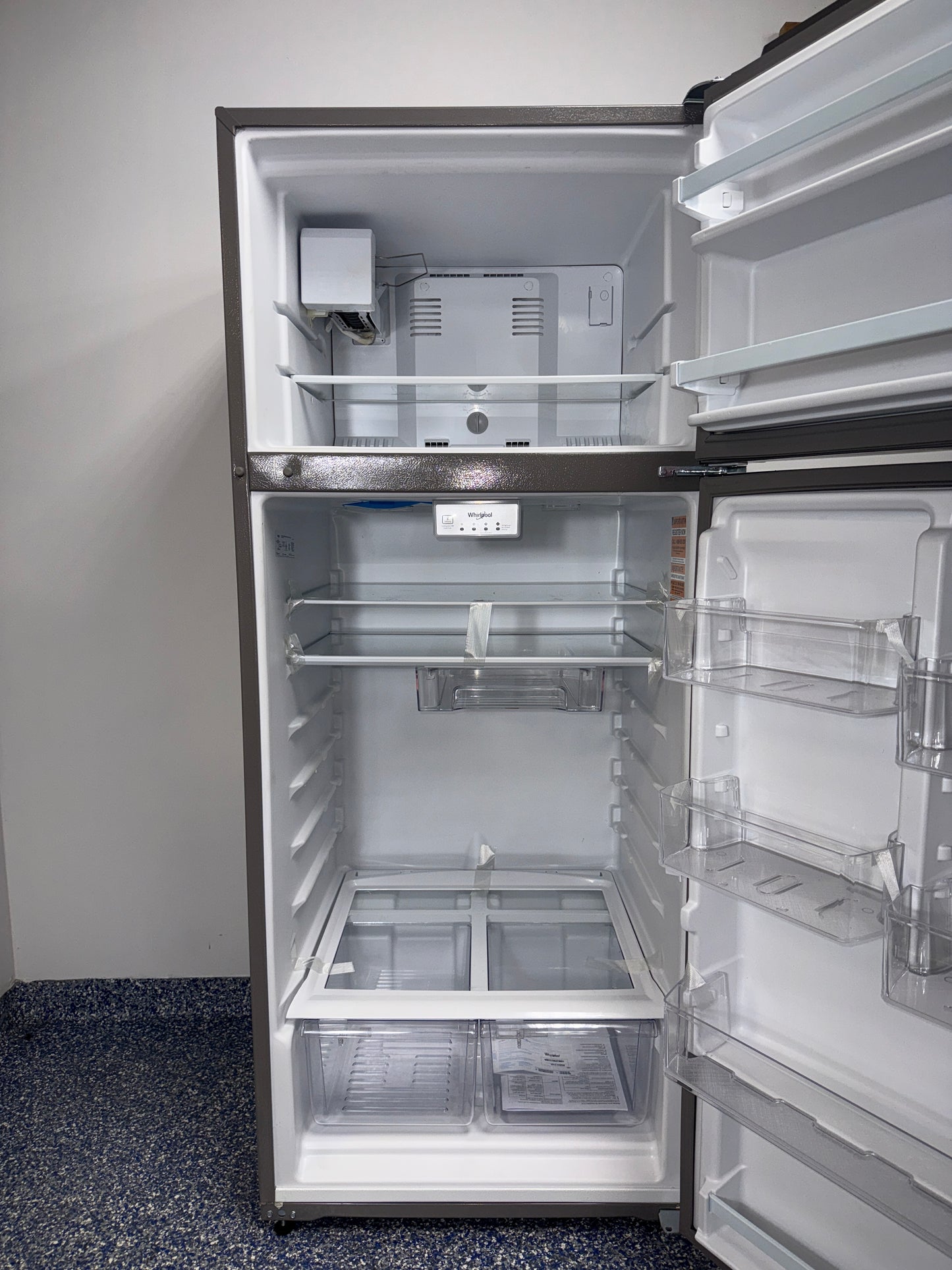 The interior of the WHIRLPOOL refrigerator, model WRT518SZFM, showing its frameless glass shelves, an ideal appliance for homes in Overland Park.