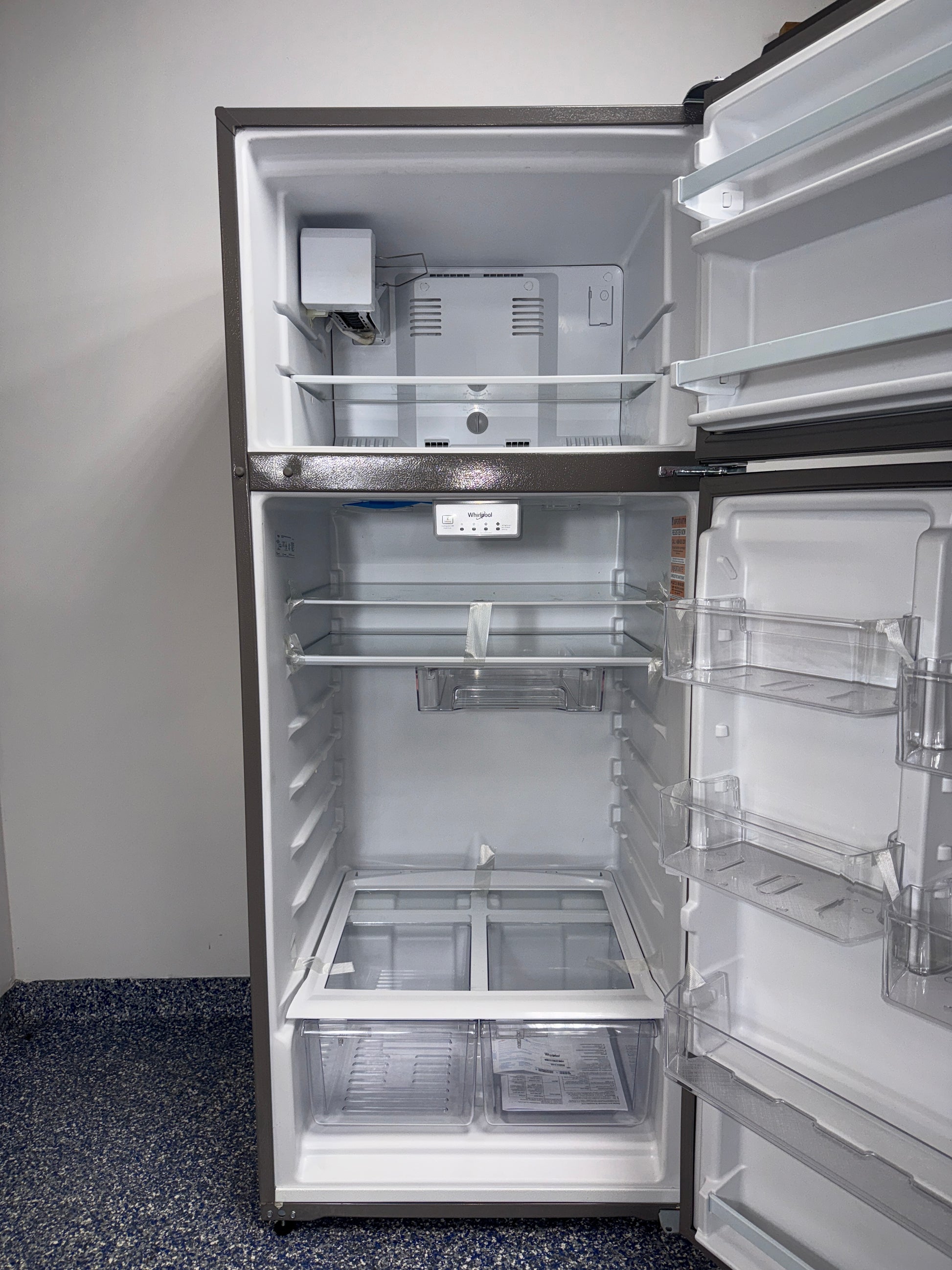 The interior of the WHIRLPOOL refrigerator, model WRT518SZFM, showing its frameless glass shelves, an ideal appliance for homes in Overland Park.