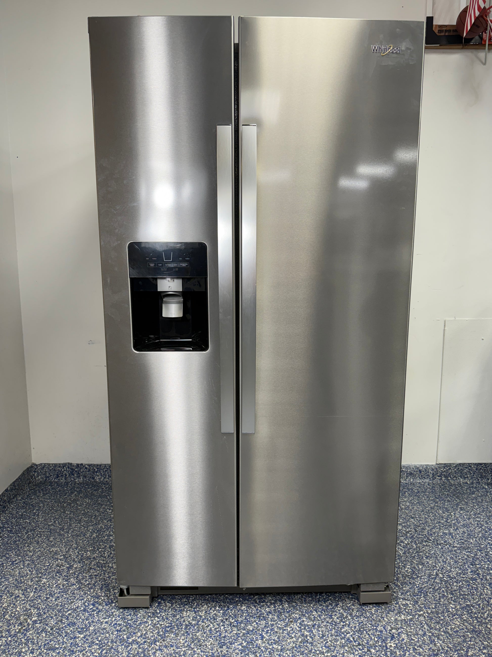 A full view of the Whirlpool WRS325SDHZ side-by-side refrigerator in fingerprint-resistant stainless steel with an exterior water and ice dispenser.