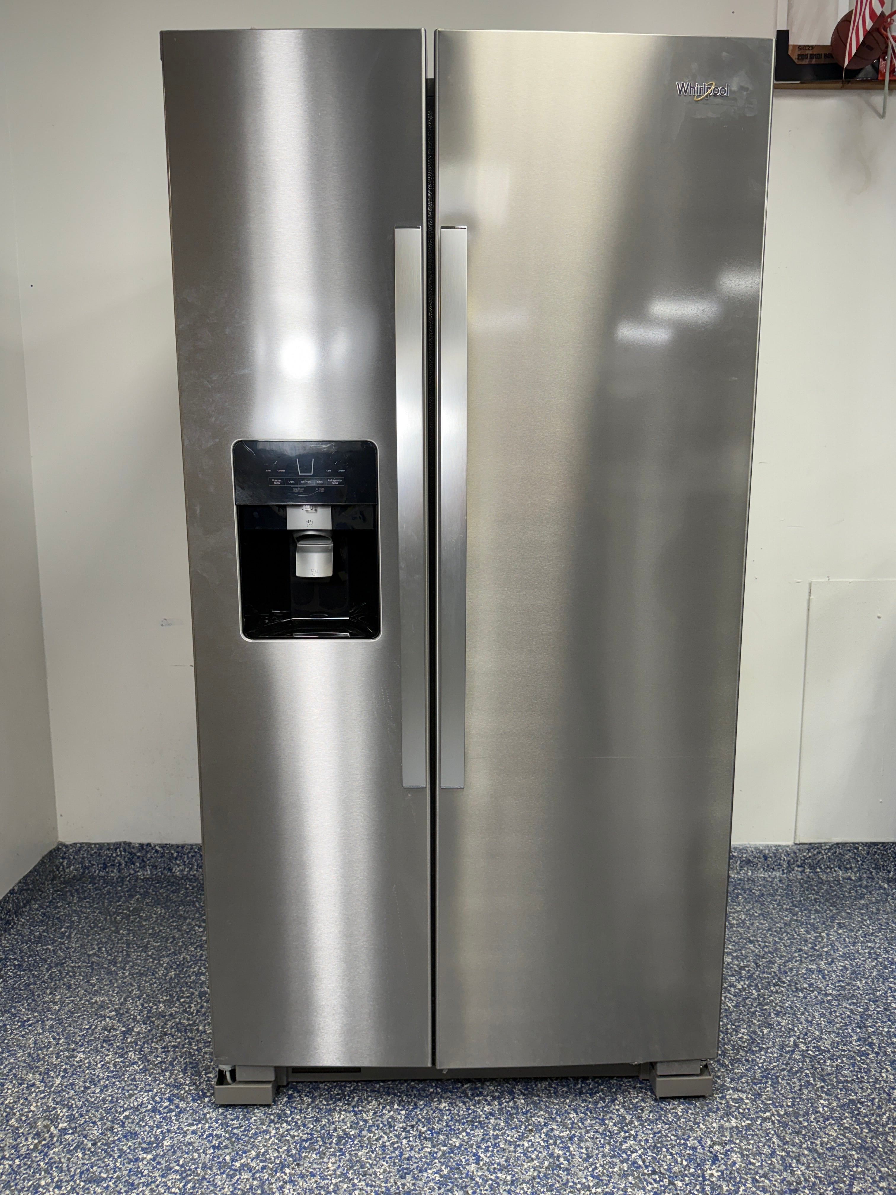 A full view of the Whirlpool WRS325SDHZ side-by-side refrigerator in fingerprint-resistant stainless steel with an exterior water and ice dispenser.